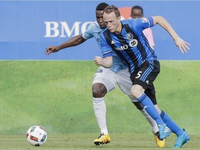 Montreal Impact's Wandrille Lefèvre, right, battles for the ball against New York City FC defender Jefferson Mena during the first half of their MLS soccer match at Saputo Stadium in Montreal on July 17, 2016.