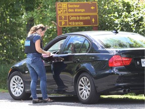 Longueuil police officer speak to a motorist at the entrance of Mont-Saint-Bruno park on September 9, 2016.Longueuil Police set up a command post  to collect information about an attack on a woman in her 50s last week on the trail of the park located on the South shore of Montreal.