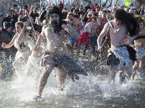 Participants run into Lake Ontario as they take part in the Courage Polar Bear Dip in Oakville, Ont., on Sunday, Jan. 1, 2017.