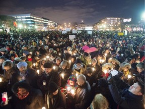 People attend a vigil for victims of the mosque shooting in Quebec City Monday, Jan. 30, 2017 in Montreal.