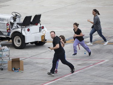 People run on the tarmac at Fort Lauderdale–Hollywood International Airport, Friday, Jan. 6, 2017, in Fort Lauderdale, Fla., after a shooter opened fire inside a terminal of the airport, killing several people and wounding others before being taken into custody.