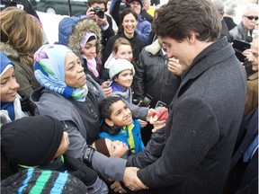 Prime Minister Justin Trudeau greets refugee families who recently arrived in Canada at an open house of the Masjid Al-Salaam Mosque in Peterborough Ont., Sunday, Jan. 17, 2016.