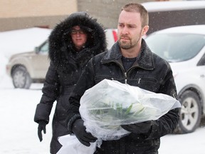 An couple approaches a mosque in Quebec City with a bouquet, Jan. 30, 2017, the morning after six people were fatally shot at the mosque.