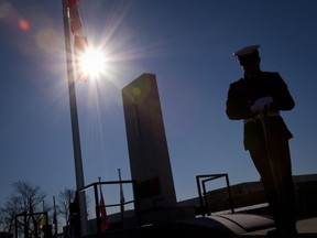 A soldier stands guard by a cenotaph during the Remembrance Day ceremony at CFB Valcartier in 2010.