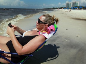 A new study finds the majority of Canadians check their office email while on holiday.

(BILOXI, MS - JULY 04: Jackie Norwood, on vacation in Biloxi, Mississippi, checks her mobile while enjoying the beach. A new study finds the majority of Canadians check their office email while on holiday, despite plans to not do any work while away.