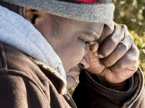 A Somali man wipes a tear after crossing the U.S.-Canada border into Canada near Hemmingford Feb. 17, 2017. A number of refugee claimants are braving the elements to illicitly enter Canada.