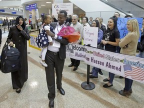 Abdisellam Hassen Ahmed, a Somali refugee who had been stuck in limbo after President Donald Trump temporarily banned refugee entries, walks with his wife Nimo Hashi, and his 2-year-old daughter, Taslim, after arriving at Salt Lake International Airport, Friday, Feb. 10, 2017, in Salt Lake City.