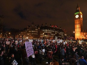 Protesters holding placards gather in front of the Elizabeth Tower, better known as "Big Ben" near the Houses of Parliament as an anti-Trump protest gets underway in London on Feb. 20, 2017, as parliament debates whether or not to allow Donald Trump a state visit.