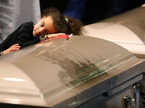 A young mourner lays her head on one of the caskets during Feb. 3 funeral services for three of the victims of the Quebec City mosque shooting. Though the city has had a Muslim community for generations, there is no Muslim cemetery in Quebec City.