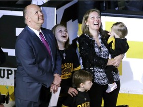 Boston Bruins head coach Claude Julien, far left, his wife Karen and their children watch a video tribute honouring him as the all-time winningest coach for the Boston Bruins, prior to an NHL hockey game against the Florida Panthers in Boston on March 24, 2016