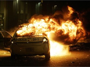 Firemen try to put out a raging fire that destroyed 5 police cars as fans rioted after the Montreal Canadiens eliminated the Boston Bruins in game 7 of the first round NHL playoffs in Montreal Monday April 21/08.