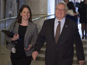 Quebec Health Minister Gaétan Barrette walks to a party caucus meeting with press attaché Julie White, Tuesday, April 5, 2016 at the legislature in Quebec City.