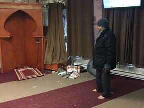A worshipper examines the broken glass and garbage inside his mosque, which was vandalized Feb. 21, 2017.