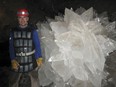 In this image provided by Mike Spilde, Mario Corsalini stands near to a gypsum rosette crystal. In a Mexican cave system so beautiful and hot that it is called both Fairyland and hell, scientists have discovered life trapped in crystals that could be 50,000 years old. The bizarre and ancient microbes were found dormant in caves in Naica, Mexico, and were able to exist by living on minerals such as iron and manganese, said Penelope Boston, head of NASA's Astrobiology Institute.