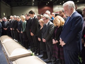 Prime Minister Justin Trudeau, Quebec City mayor Regis Labeaume and Quebec Premier Philippe Couillard gather in front of the caskets during the funeral for three of the six victims of the Quebec City mosque shooting on Friday, February 3, 2017 at the Quebec City convention centre.