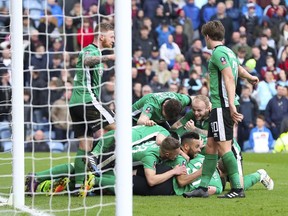 Lincoln City's Sean Raggett celebrates scoring against Burnley with teammates during the English FA Cup, fifth round soccer match at Turf Moor, Burnley, England, Saturday, Feb. 18, 2017.