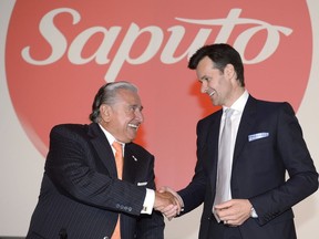Lino Saputo Jr., right, chief executive of Saputo Inc., and his father chairman Lino Saputo Sr. appear at the the annual general meeting of dairy giant Saputo Inc. in Laval, Que., on Tuesday, Aug. 4, 2015.