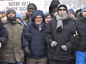 Mohamed Labidi, centre, who was present when the shooter came in the mosque, and Mohamed Yangui, right, president of the Centre Culturel Islamique de Québec, walk to the Quebec legislature in honour of the victims of a shooting on Jan. 29.