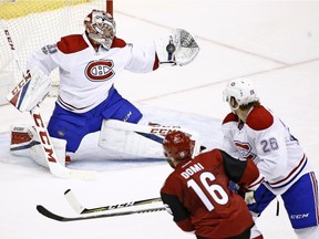 Montreal Canadiens goalie Carey Price (31) makes a glove-save on a shot by Arizona Coyotes left wing Max Domi (16) as Canadiens defenseman Jeff Petry (26) defends during the second period of an NHL hockey game Thursday, Feb. 9, 2017, in Glendale, Ariz.