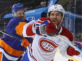 Canadiens' David Desharnais is checked into the boards by Islanders' Travis Hamonic in 2016.