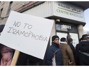 People rally outside the Khadijah Masjid Islamic centre in the Montreal borough of Pointe-Saint-Charles, Friday, February 3, 2017, in a show of support after vandals broke a window and pelted the building with eggs.