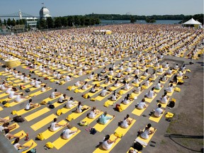 Thousands of people take part in a yoga session at Montreal's Old Port in 2014. For many practitioners, yoga's lack of intensity makes it a valuable tool in buffering the physical effects of an active lifestyle.