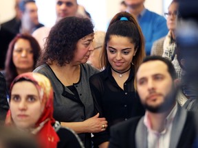 Syrian refugee families during an event in December 2016 to mark the anniversary of the first chartered flight of Syrian refugees last year. Hakima Kalif, from Les Oeuvres Marie-Anne Lavallée, middle left, who sponsored Syrian refugee Venice Alzerawi, middle right, comforted her during the commemoration.