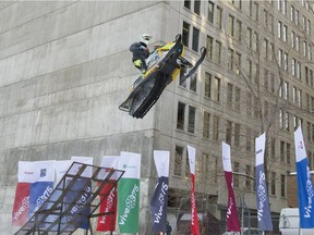 A stunt performer powers a snowmobile mid-air off a ramp during a freestyle snowmobile demonstration in downtown Montreal on Wednesday Dec. 14, 2016.