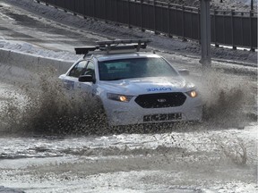 A police car splashes through a flooded section of  Pie IX boulevard near Henri-Bourassa in Montreal after heavy freezing rain blocked the drains.