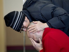 A man who is overcome with grief while praying is comforted by another at the Centre Culturel Islamique de Québec in Quebec City, Feb. 1, 2017, after some people were allowed inside for the first time since a mass shooting at the centre, Jan. 29.