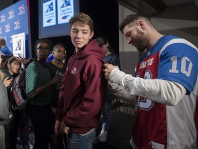 MONTREAL, QUE.: FEBRUARY 10, 2017 -- Montreal Alouettes linebacker Marc-Olivier Brouillette, right, signs autographs for students at FACE school in Montreal, Friday February 10, 2017.  Members of the team visited the school as part of their kick off Together at School community program.  (Phil Carpenter / MONTREAL GAZETTE)  ORG XMIT: 0211 spt als standalone