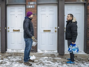 Neighbours Giovanni Paquin, left, and Carlo Chavez speak outside their apartment block on the corner of Girouard Ave. and St-Jacques St. in Montreal on Sunday, Feb. 12, 2017. According to Paquin, water to the building was shut off on Friday at 6:30 a.m. because of nearby construction and two days later, the building is still without water.