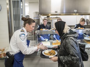 SPVM communications commander Marie-Claude Dandenault helps serve meals at the Old Brewery Mission in Montreal on Tuesday, February 14, 2017.
