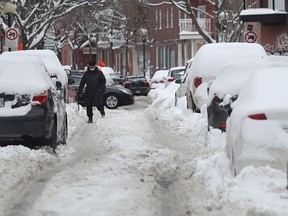 Raymonde Castonguay walks in the middle of St-Philippe St. to avoid the icy sidewalk in the south west of Montreal on February 16, 2017.