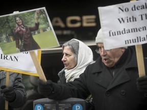 Roghayeh Azizi Mirmahaleh, centre, takes part in protest outside the federal immigration and refugee offices in Montreal Feb. 21, 2017. Mirmahaleh is to be deported to Iran Feb. 28.