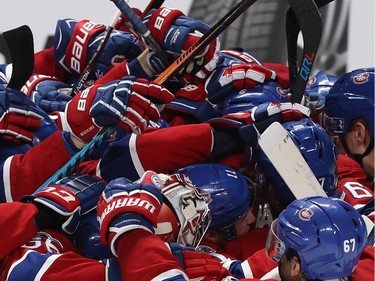 Montreal Canadiens' Alex Galchenyuk, not visible,  is mobbed by the gloves and sticks of his teammates after scoring the game-winning goal during overtime period NHL action in Montreal on Tuesday Feb. 28, 2017 against the Columbus Blue Jackets.