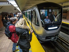 Passengers take photos as the new Metro AZUR train cars arrive at Henri-Bourassa metro for the first public ride in the orange line in Montreal on Sunday, February 7, 2016.