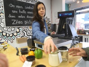 Martine Gariepy serves a client at Epicerie Loco, a zero-waste grocery store in Montreal. Customers bring their own bags and containers to shop.