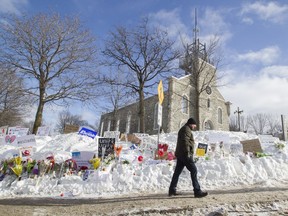 A man walks past a makeshift memorial in front of the Centre Culturel Islamique de Québec in Quebec City, after pausing in front of it, Jan. 31, 2017. Six Muslim men were shot to death and 19 injured in the mosque.