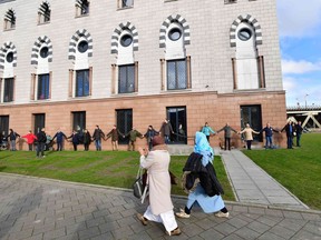People form a human chain around the Essalam mosque during the midday prayer Feb. 3, 2017, in Rotterdam. They formed the ring of peace in solidarity after the attack on a mosque in Quebec City that left six Muslim men dead.