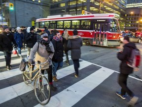 Pedestrians make their way across Bay St. at King St. W. in downtown Toronto, Ont. on Thursday January 26, 2017.