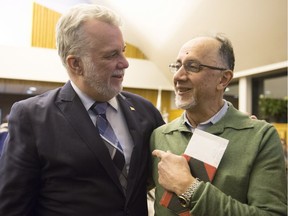 Quebec Premier Philippe Couillard, left, speaks to Boufeldja Benabdallah, co-founder of the Quebec Islamic Centre, at a catholic mass in communion with the victims of the mosque shooting, Tuesday, January 31, 2017 in Quebec City.