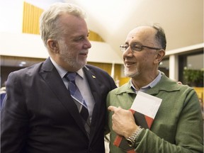 Quebec Premier Philippe Couillard, left, speaks to Boufeldja Benabdallah, co-founder of the Quebec Islamic Centre, at a Catholic mass in solidarity with the victims of the mosque shooting, Tuesday, January 31, 2017 in Quebec City.