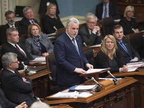 Quebec Premier Philippe Couillard, centre, speaks in a motion to honour the victims of the mosque shooting, Tuesday, February 7, 2017 at the legislature in Quebec City.