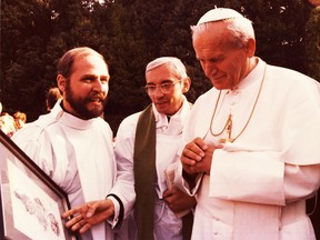 Fall of 1979: Msgr. Michael Dylag (left) gives Pope John Paul II an Aislin original.