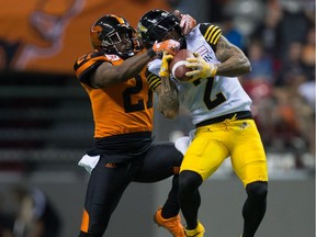 Hamilton Tiger-Cats' Chad Owens, right, makes a reception as B.C. Lions' Ryan Phillips defends during the second half of a CFL football game in Vancouver, B.C., on Saturday August 13, 2016.