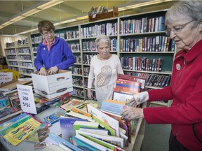 The end of the monthly book sale at Hudson's War Memorial Library is just the beginning for volunteers Ute Wilkinson, left, Janis Morrison Bates and Marion Daigle.  Remainder books are boxed up and sent to various organizations across the province.