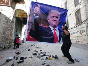 Photo of the day: A Palestinian demonstrator throws an old shoe at a poster of U.S. President Donald Trump Feb. 24, 2017, as they protest against his support of Israel and demand for the Israeli army to reopen Shuhada St., which is largely closed off to Palestinians, near a Jewish settler enclave in the heart of the flashpoint West Bank city of Hebron.