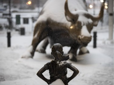 The Fearless Girl statue, installed around International Women's Day, shoulders a dusting a snow opposite Wall Street's famous bull on March 14, 2017 in New York City. The blizzard warning for New York City was later cancelled but other parts of eastern Canada and the United States were hit by 40cm or more of snow.