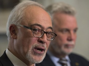 Quebec Finance Minister Carlos Leitão announces the date for his next budget speech before a party caucus meeting on Tuesday, March 14, 2017 at the legislature in Quebec City. Quebec Premier Philippe Couillard, right, looks on.